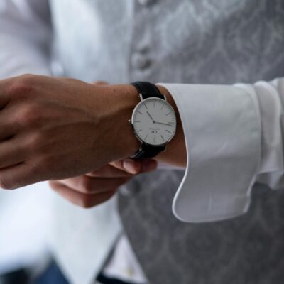 Close-up of a man adjusting his elegant wristwatch, showcasing precision and style.