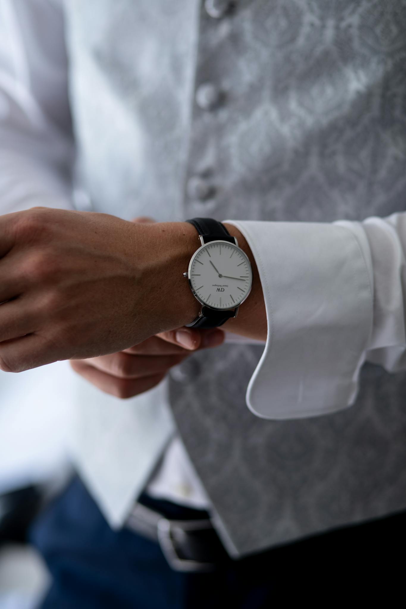 Close-up of a man adjusting his elegant wristwatch, showcasing precision and style.