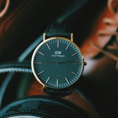 Close-up of a sleek wristwatch surrounded by leather accessories, highlighting timeless elegance.