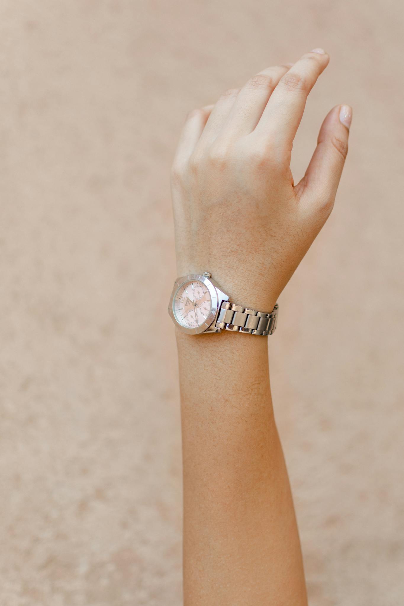Close-up shot of a woman's hand wearing an elegant wristwatch, showcasing minimalist design and style.