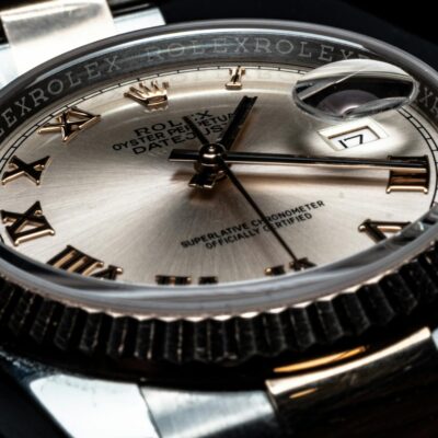 Detailed close-up of a luxury Rolex wristwatch displaying its elegant design and date feature.