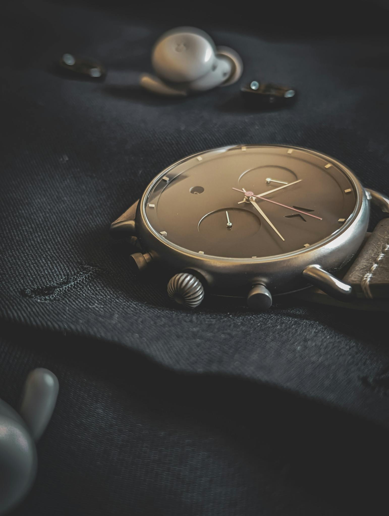 Stylish wristwatch lying on a dark fabric, emphasizing luxury and elegance.